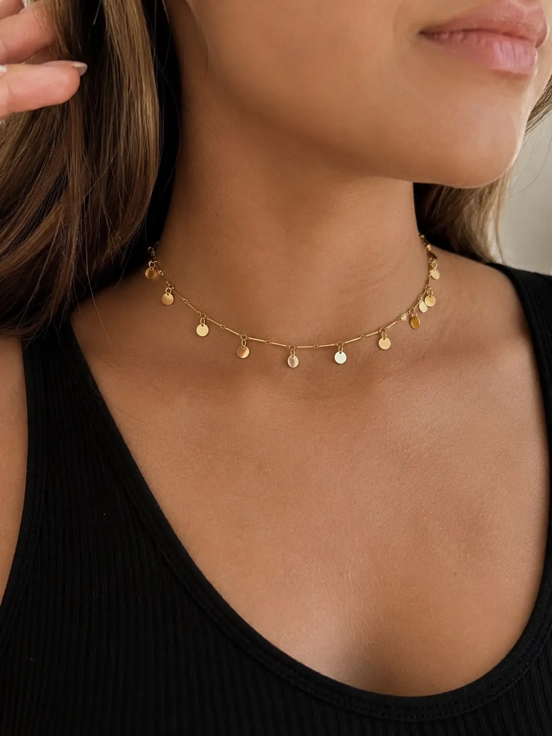 Modelo usando uma choker dourada de moedinhas